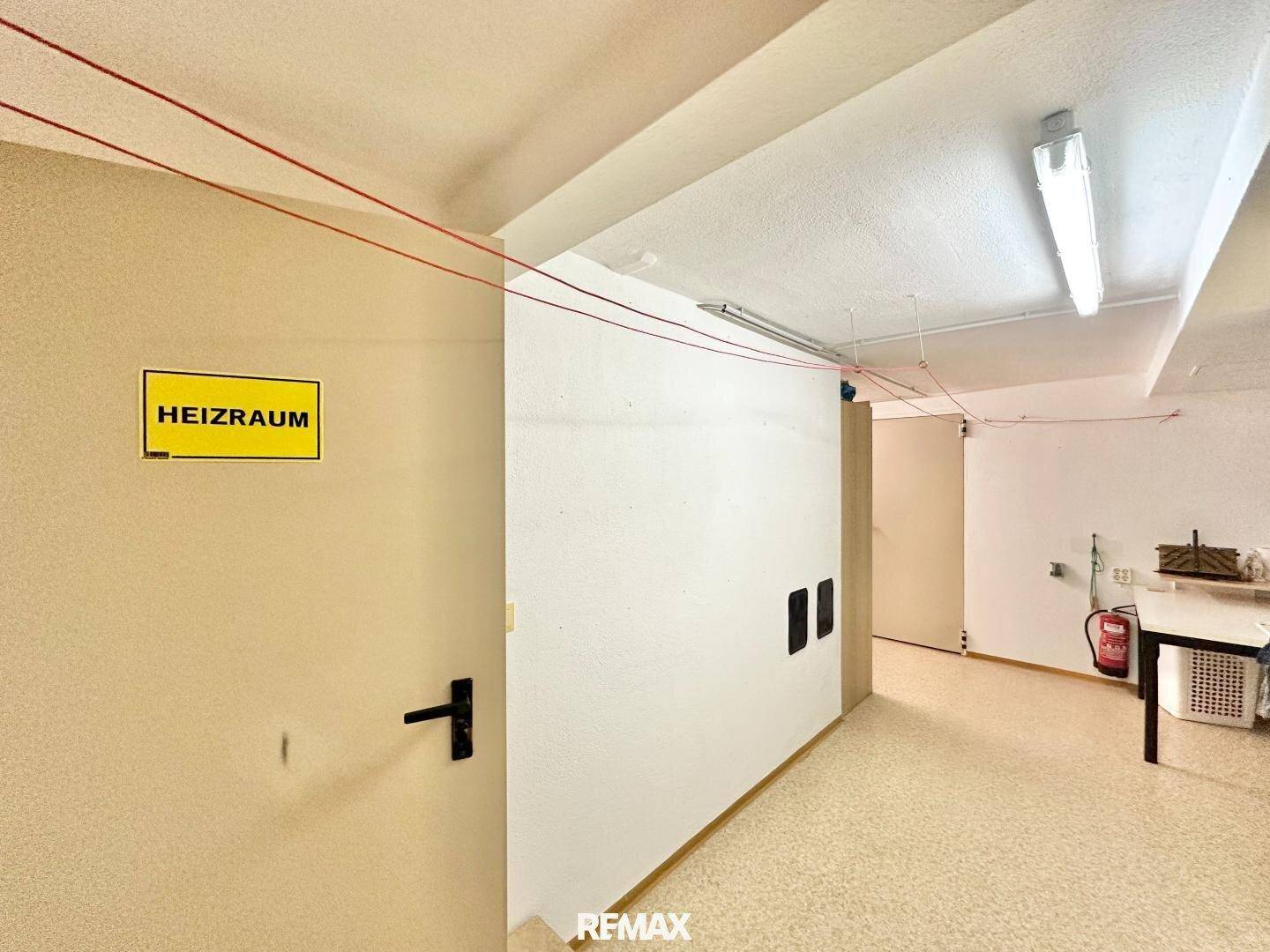 Flur im Kellerbereich mit Zugang zum Heizraum und einfacher Ausstattung.