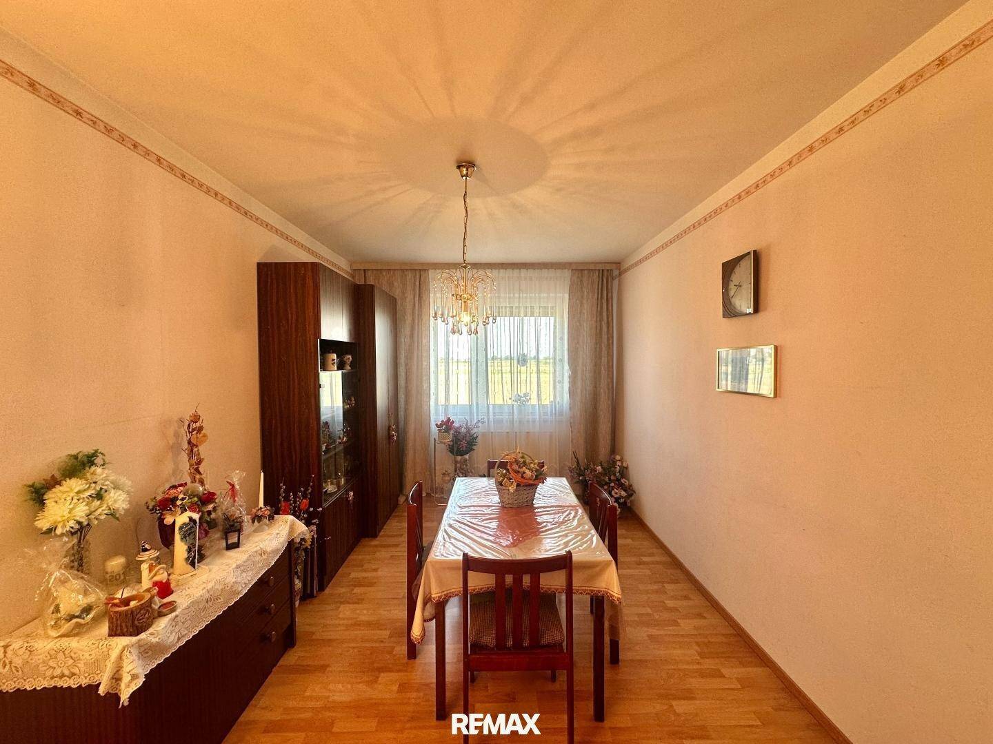 Helles Esszimmer mit traditionellem Holztisch und Stühlen, dekoriert.
