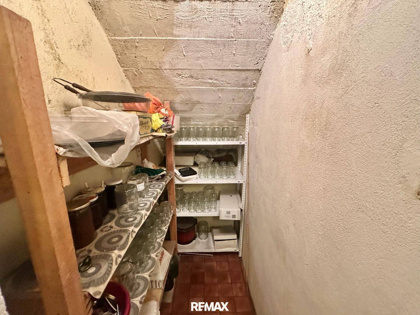 Abstellraum im Keller mit Regalen und Vorräten, einfacher Ausbau.