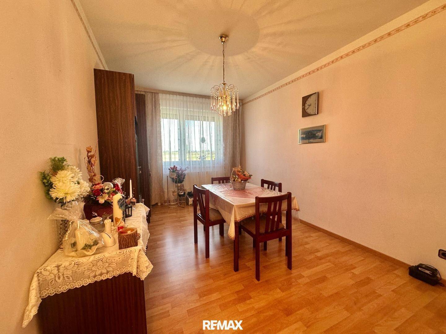 Esszimmer mit Holztisch, Stühlen und Kronleuchter, hell und freundlich.
