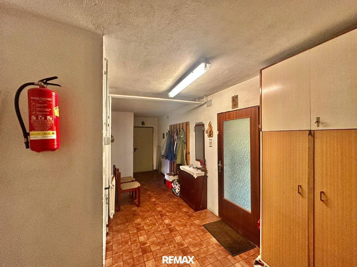 Flur im Untergeschoss mit Fliesenboden und Zugang zu weiteren Räumen.