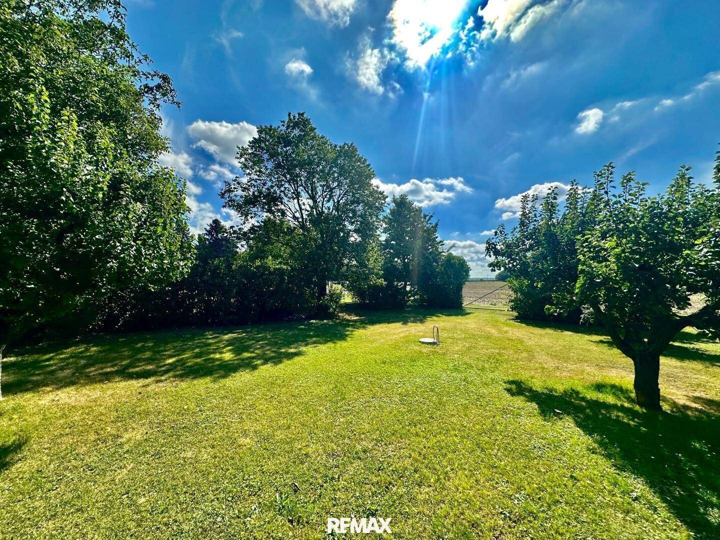 Weitläufiger Garten mit Blick auf die umliegende Landschaft und Felder in der Ferne.