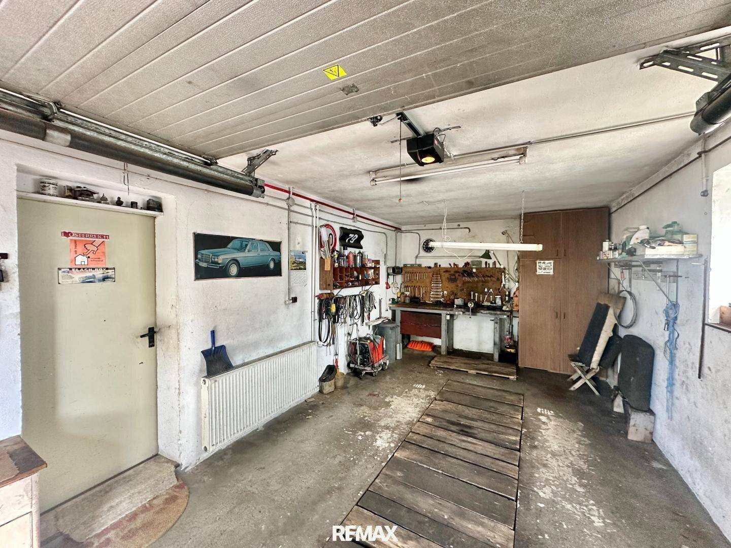 Geräumige Garage mit Werkbank, Werkzeugen und viel Stauraum, ideal für Heimwerker.
