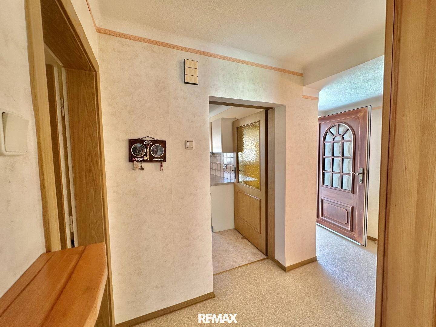 Traditioneller Eingangsbereich mit Holzdetails und Blick in die Küche sowie einen weiteren Raum.