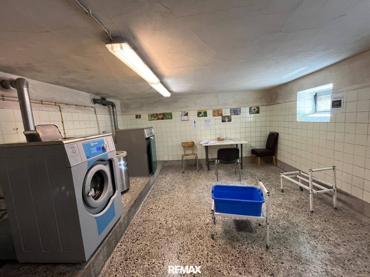 Gemeinschaftlicher Waschraum im Keller mit Waschmaschinen und Waschbecken, praktisch für alle Bewohner.
