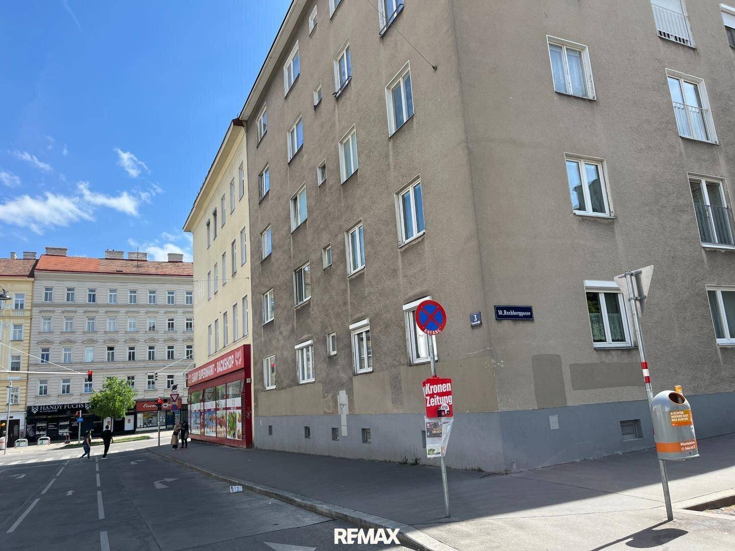 Außenansicht des Gebäudes von der Straße, mit Fenstern und einem Straßenschild.