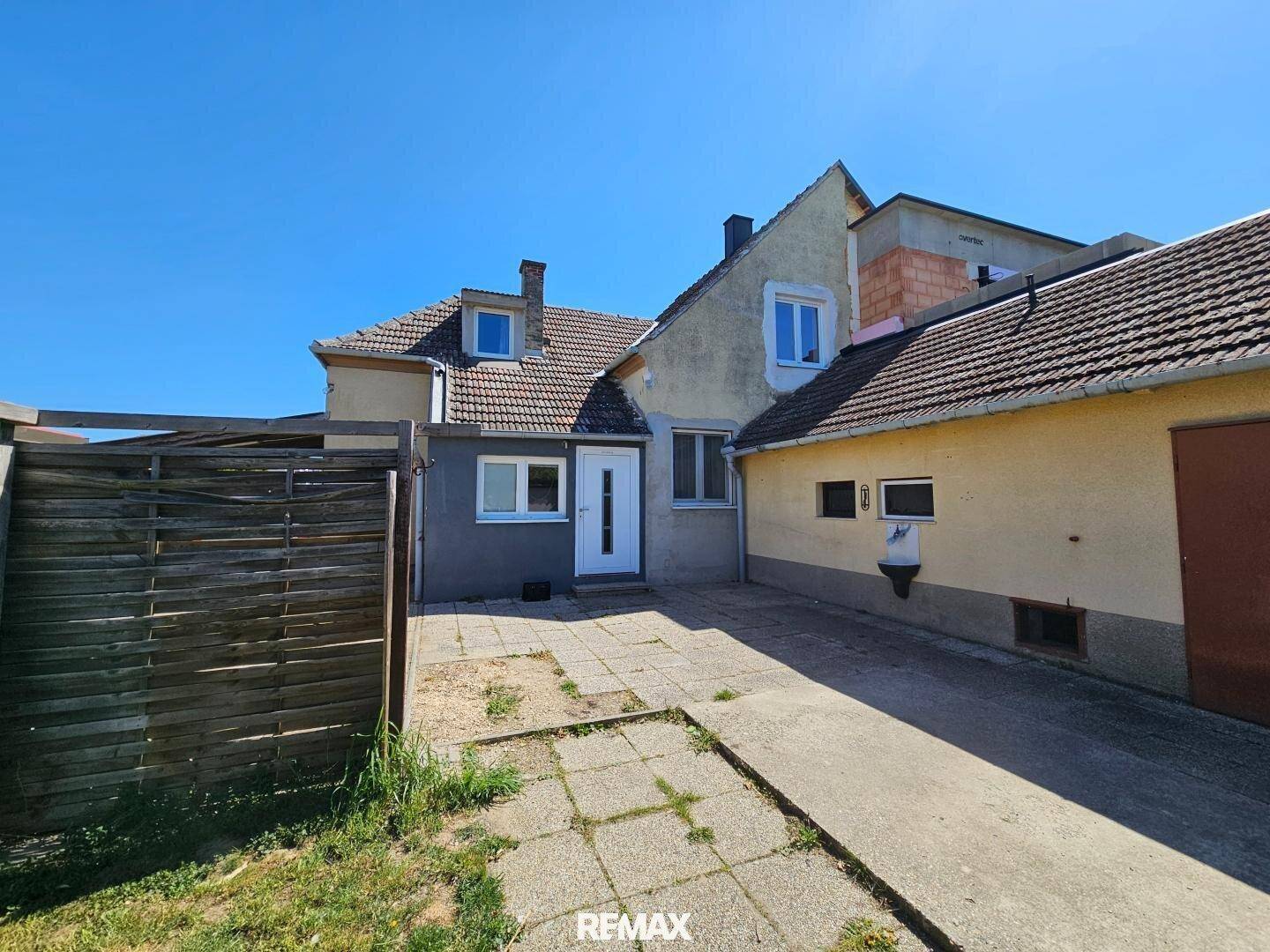 Rückseite des Hauses mit gepflastertem Hof und Zugang zum Garten.