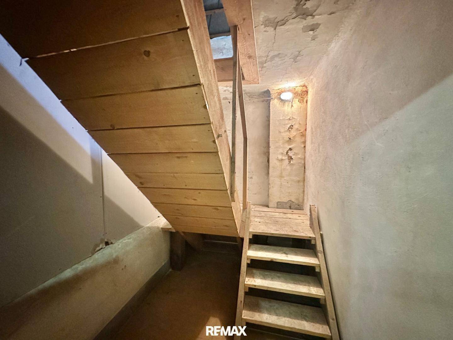 Rustikale Holztreppe in einem unfertigen Bereich mit rauen Wänden.