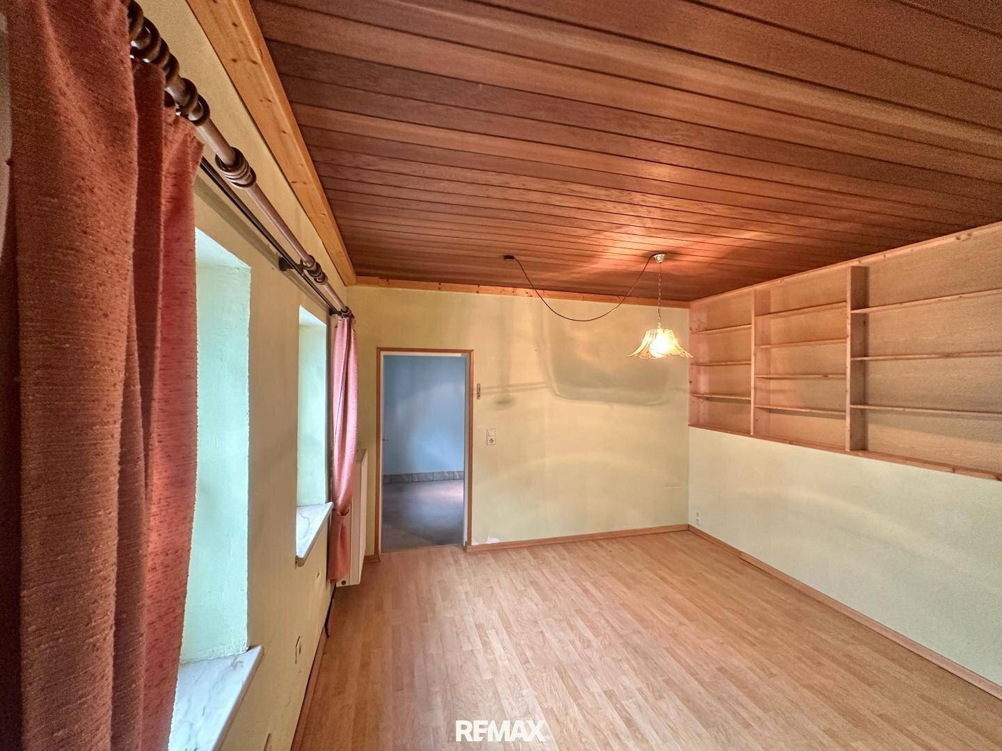 Helles Zimmer mit Holzboden, Holzdecke und eingebauten Regalen, vielseitig nutzbar.