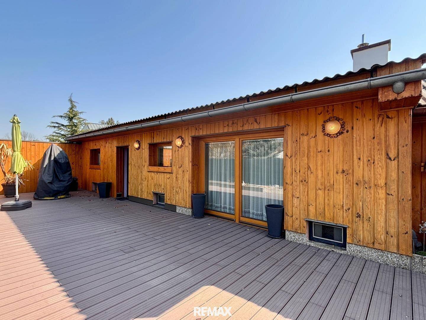 Große Holzterrasse am Haus mit viel Platz für Outdoor-Aktivitäten.