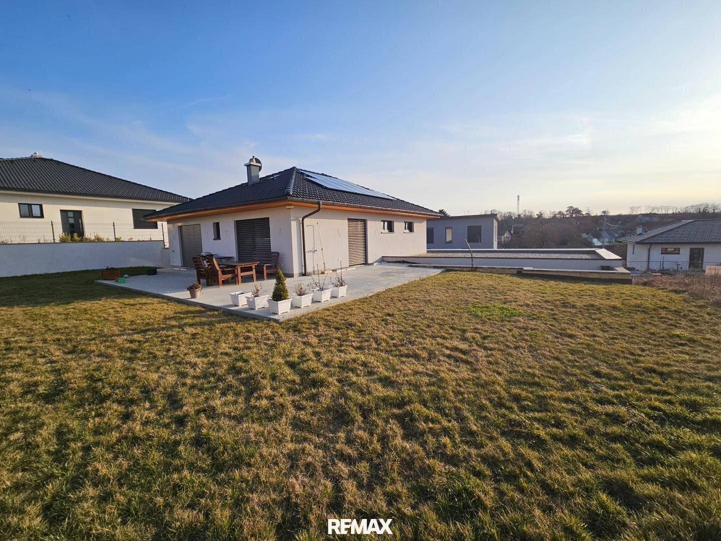 Weitläufiger Gartenbereich um ein modernes Haus mit Terrasse und viel Grünfläche.