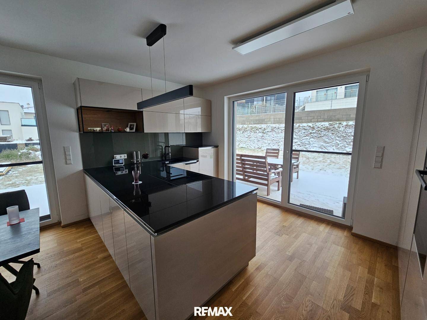 Helle Küche mit Zugang zur Terrasse, moderner Ausstattung und viel Tageslicht.