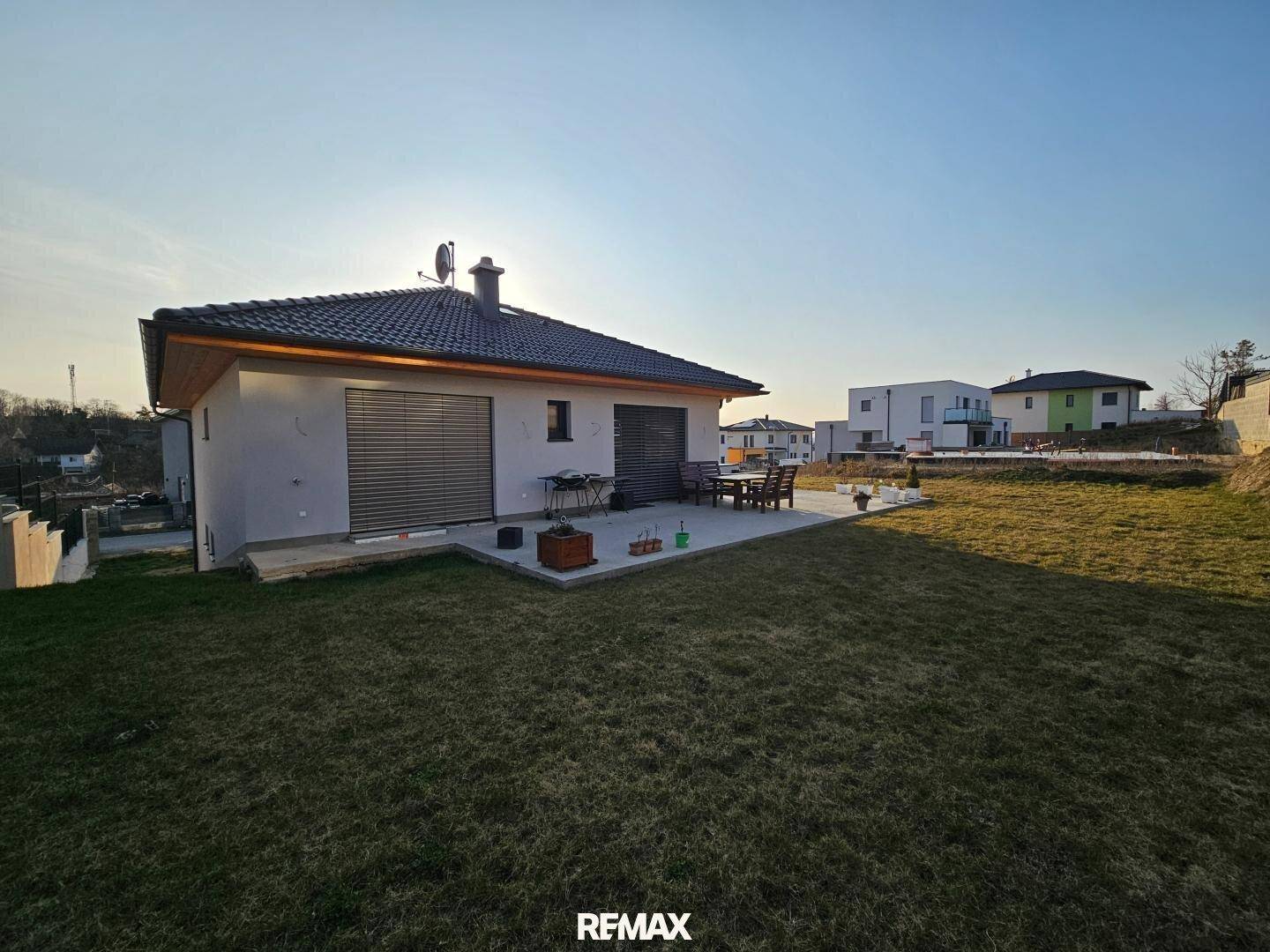 Sonniger Außenbereich mit Terrasse und Rasenfläche, ideal für Entspannung im Freien.