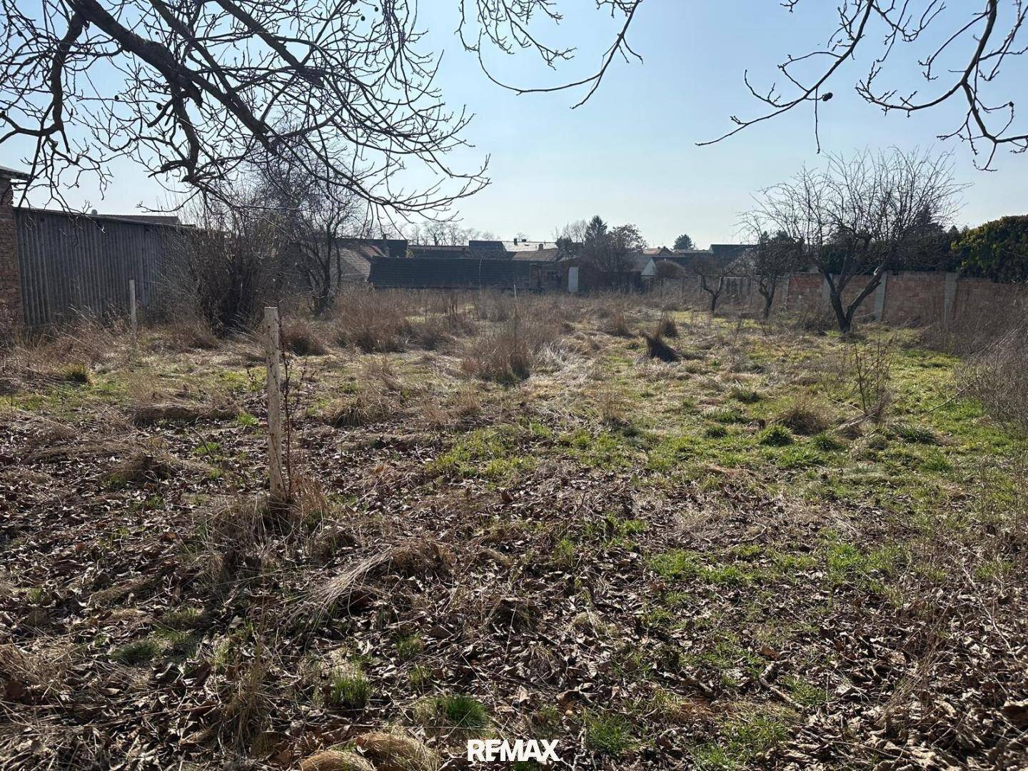 Unbebautes, verwildertes Grundstück mit Blick auf die umliegende ländliche Bebauung.
