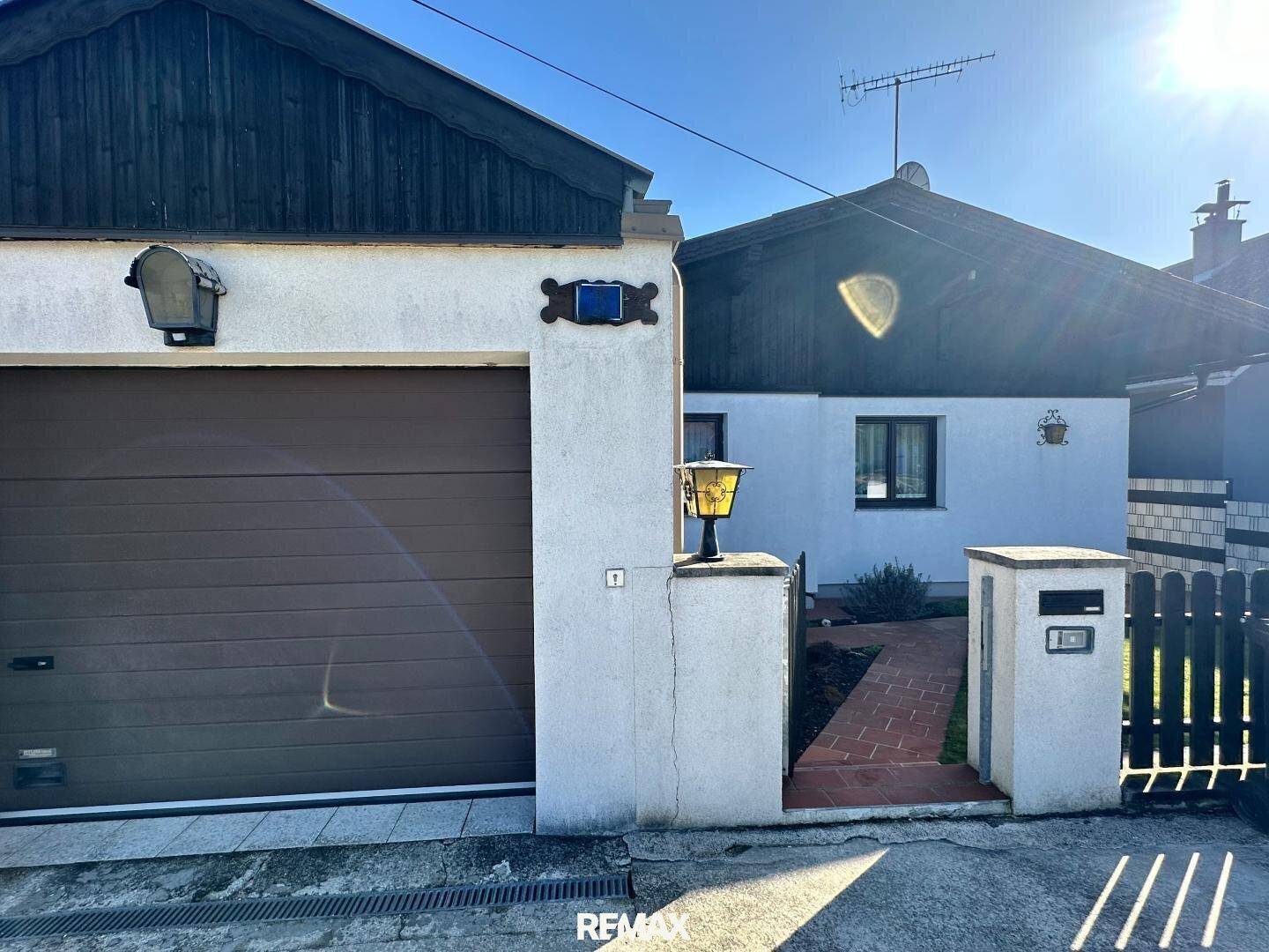 Vorderansicht des Hauses mit Garage, Einfahrt und gepflegtem Eingangsbereich.