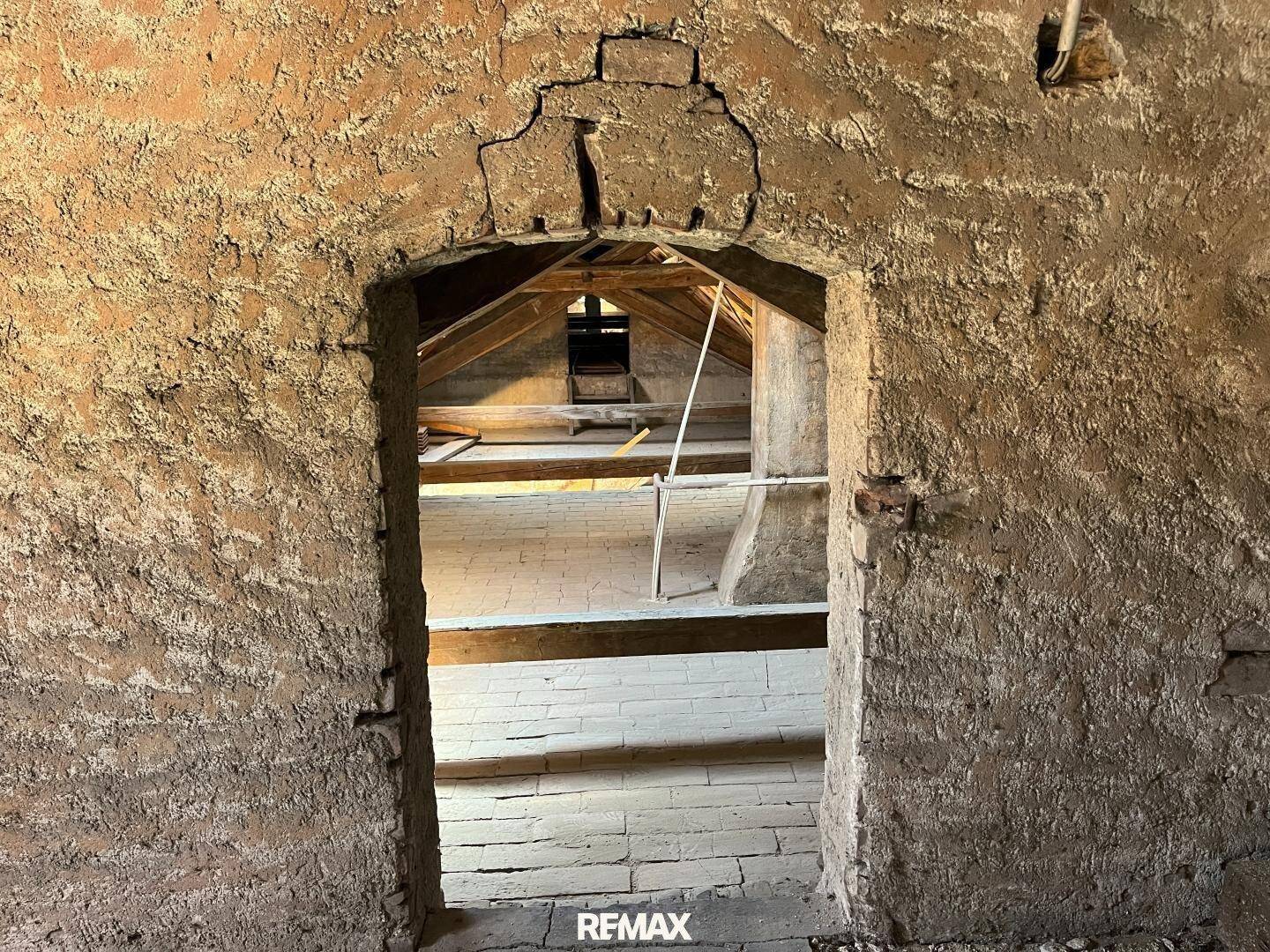 Dachboden mit Holzbalken und unverputzten Wänden, bereit zum Ausbau und zur Gestaltung.
