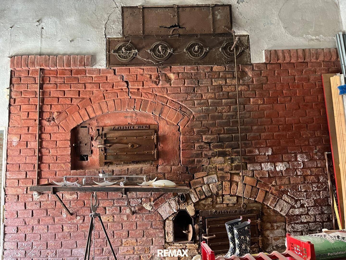 Historischer Backofen oder Kamin aus Ziegeln mit Metalltüren, ein rustikales Element.