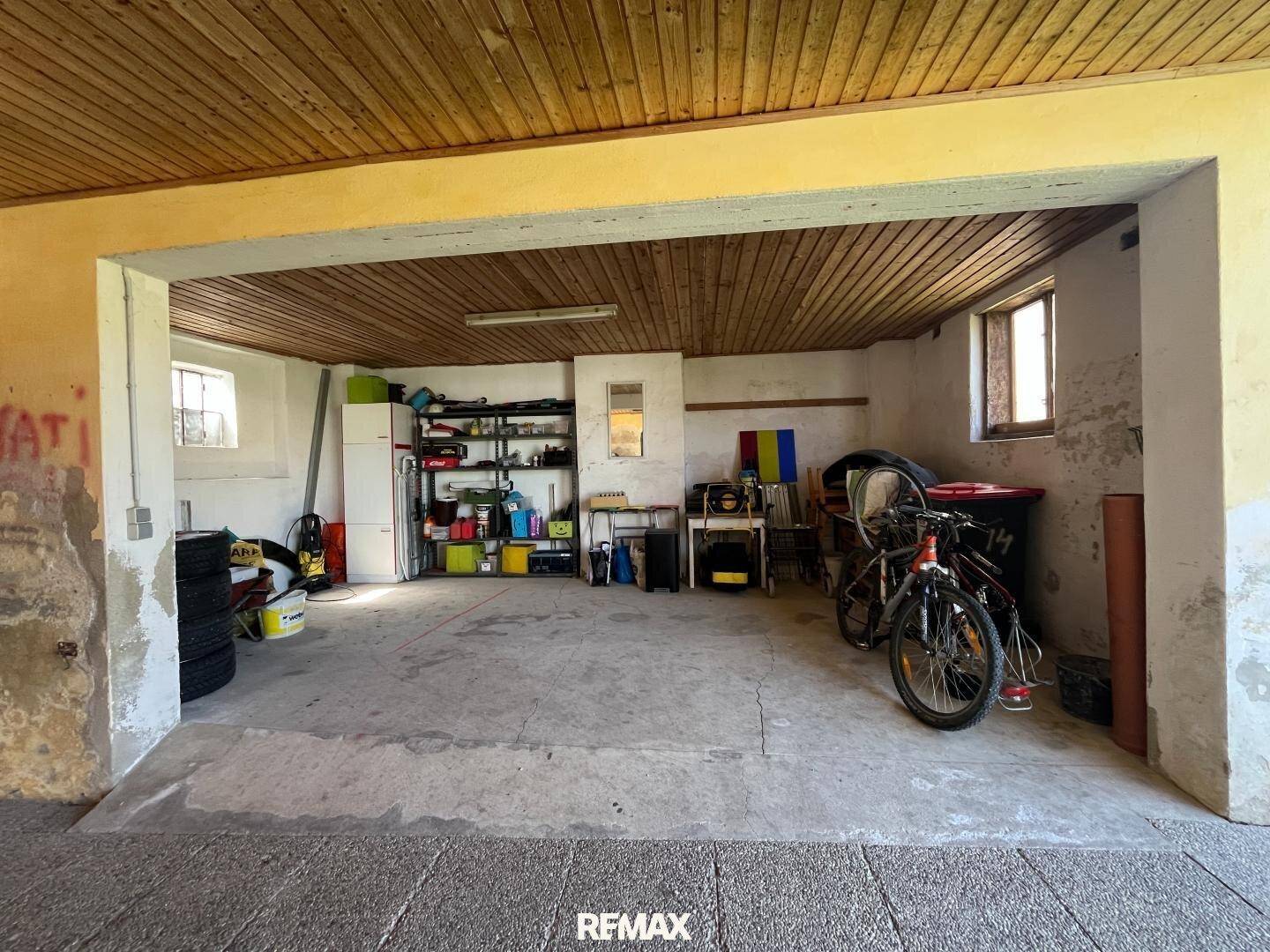 Geräumige Garage mit Holzdecke, Regalen und Fahrrädern, bietet viel Platz.