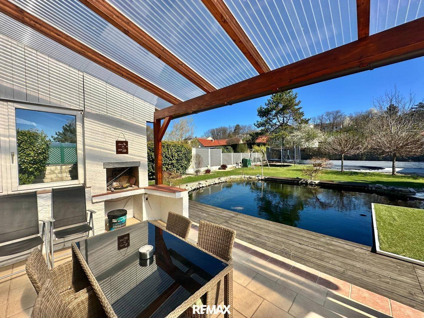 Gemütliche Terrasse mit Essbereich, Grill und direktem Zugang zum Gartenteich.
