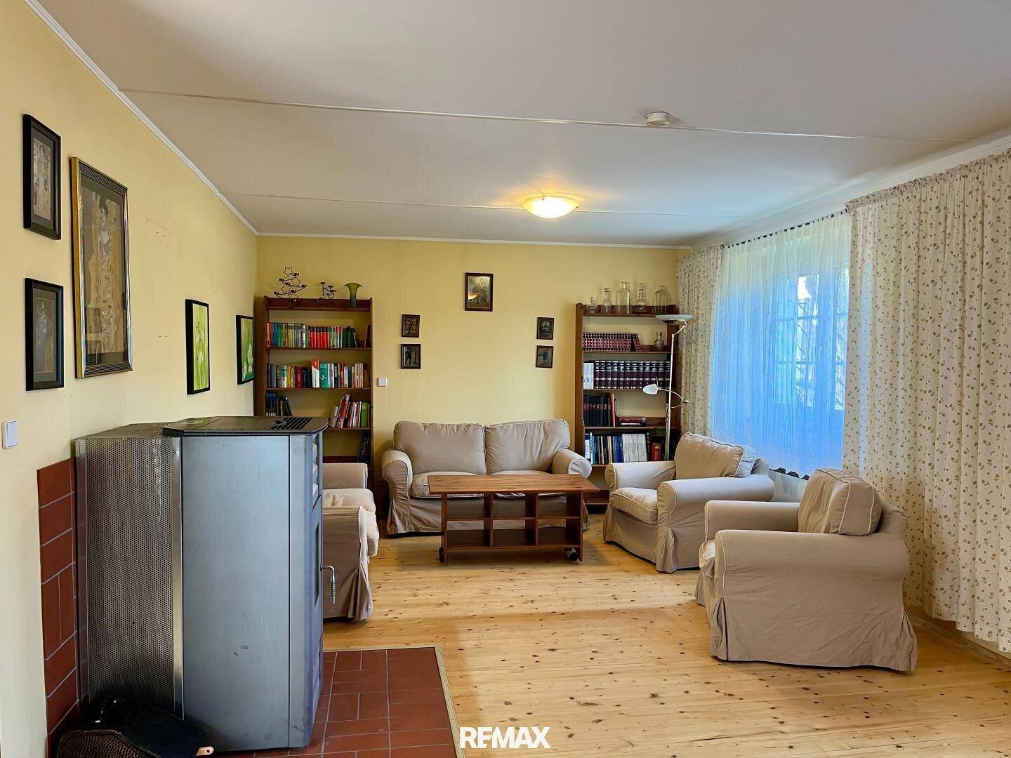 Gemütliches Wohnzimmer mit Holzboden, bequemen Sofas und Bücherregalen.