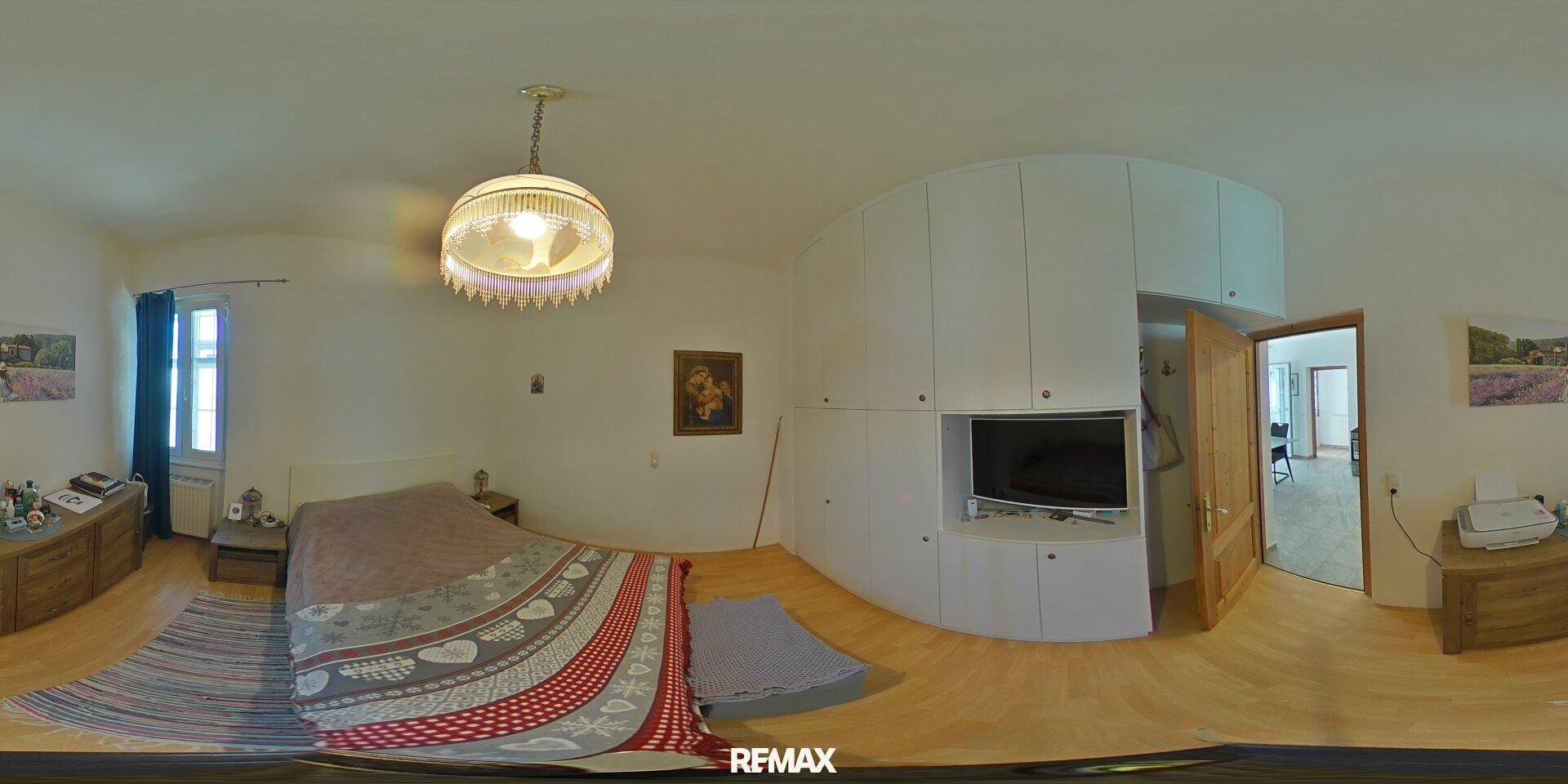 Gemütliches Schlafzimmer mit Einbauschränken, Holzboden und traditioneller Deckenleuchte.