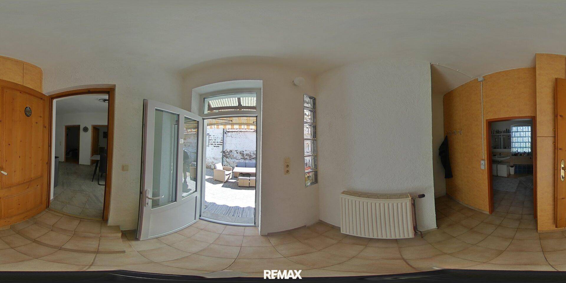Eingangsbereich mit Fliesenboden und direktem Zugang zu einer sonnigen Terrasse.