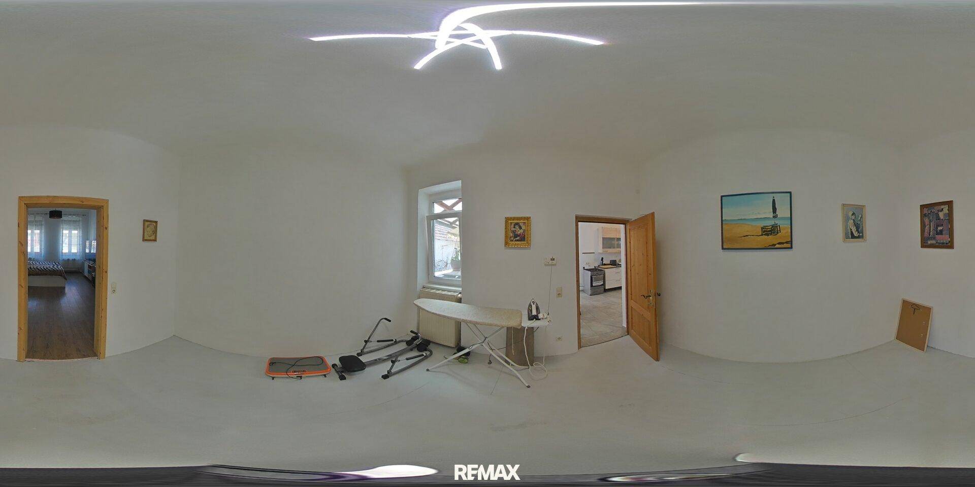 Heller Mehrzweckraum mit Fenster und einfacher Einrichtung, ideal als Büro oder Hobbyraum.