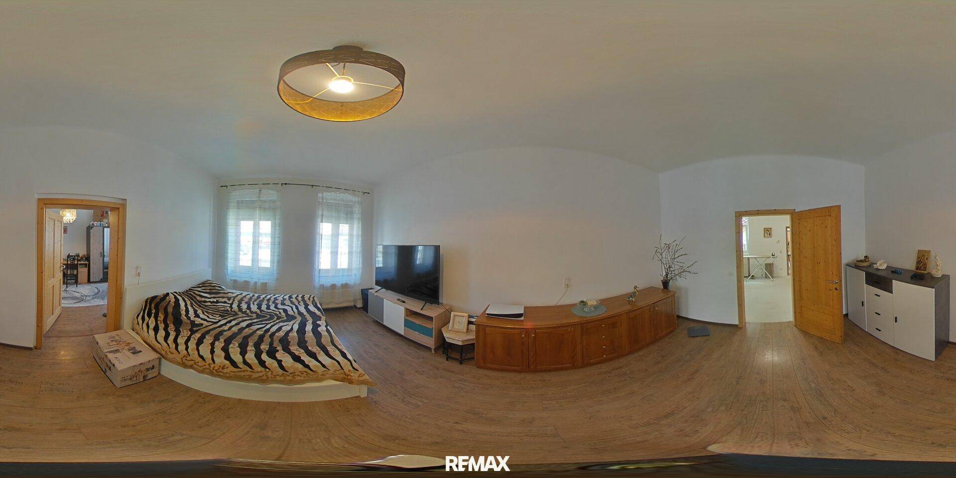 Geräumiges Schlafzimmer mit Holzboden, großem Bett und Kommode, hell und einladend.