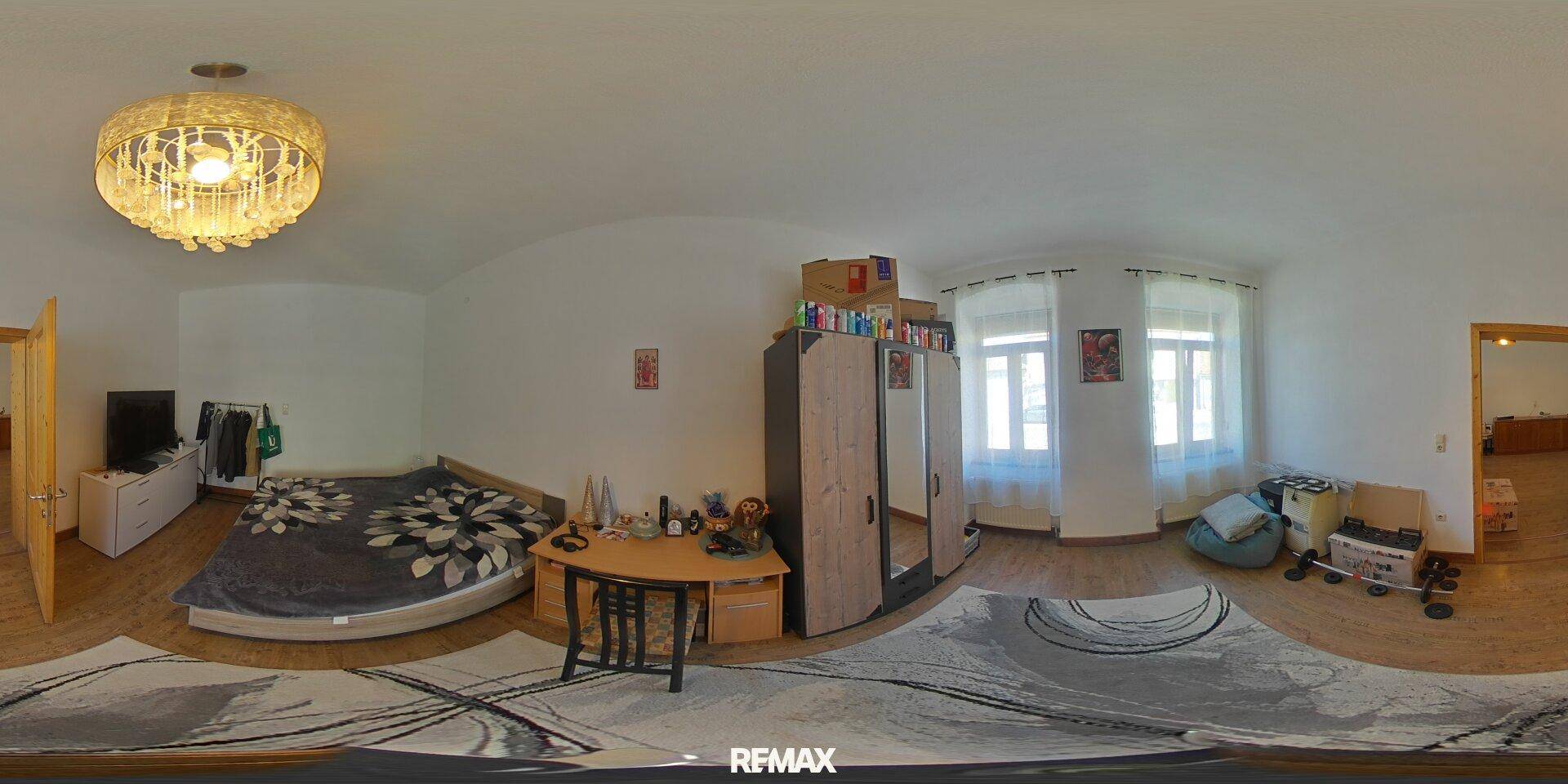 Helles Schlafzimmer mit Holzboden, Schreibtisch und Kleiderschrank, ideal für Kinder oder Gäste.