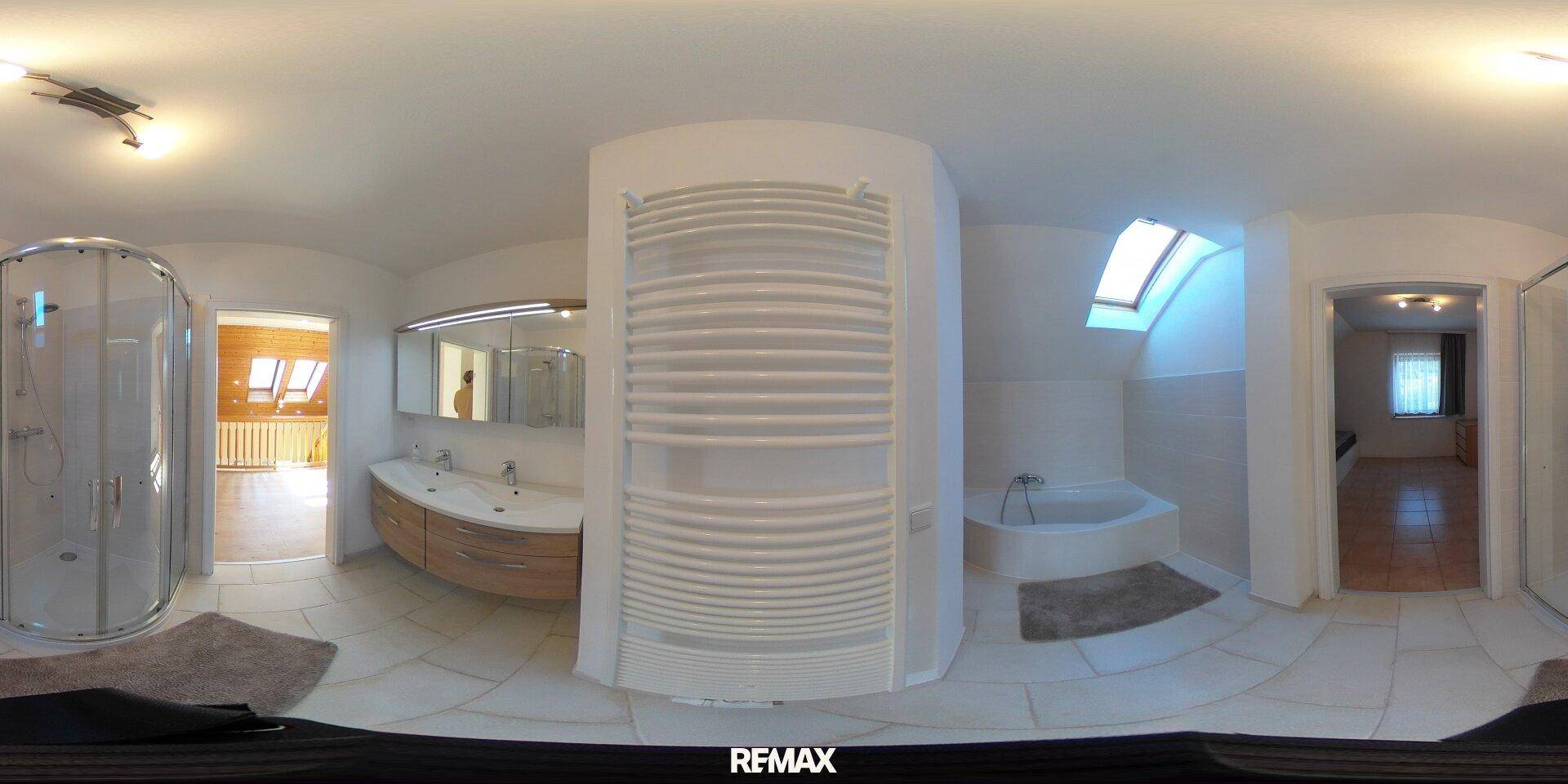 Geräumiges Badezimmer mit Badewanne, Duschkabine, Doppelwaschbecken und einem beheizten Handtuchhalter.