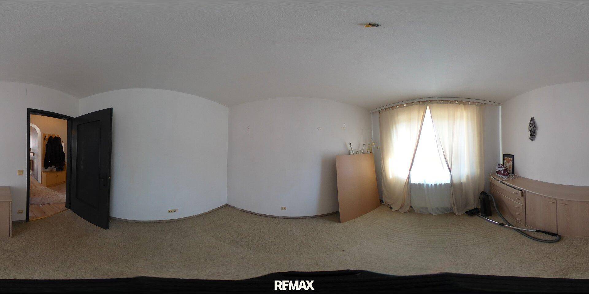 Panoramablick auf ein leeres Schlafzimmer mit Teppichboden und Fenster.