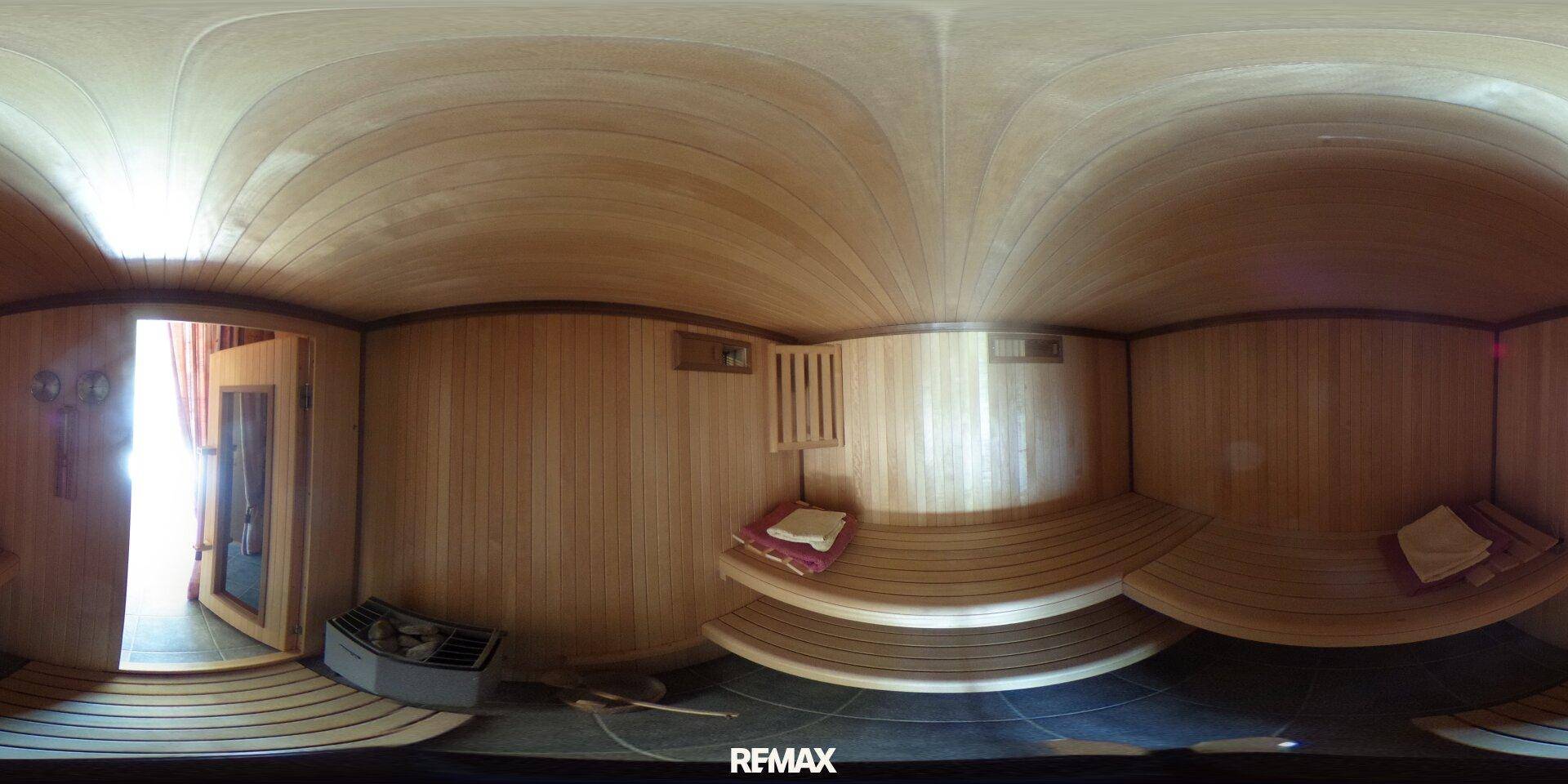 Gemütliche Holzsauna mit mehrstufigen Bänken und einem Saunaofen, ideal zur Entspannung.
