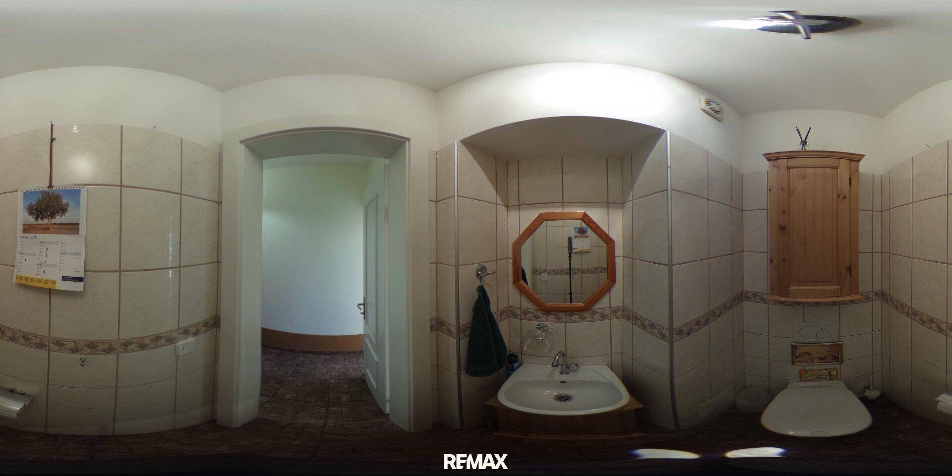 Kleines Badezimmer mit WC, Waschbecken und gefliesten Wänden, ausgestattet mit einem Holzschrank.
