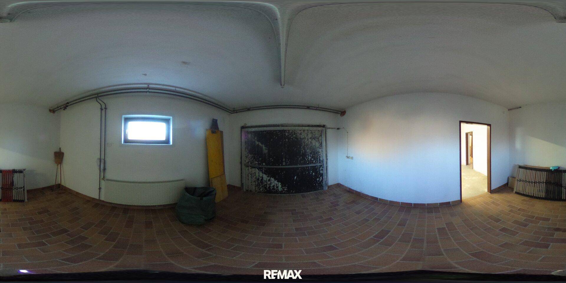 Geräumige Garage im Kellergeschoss mit Fliesenboden und Fenster, bietet Platz für Fahrzeuge.