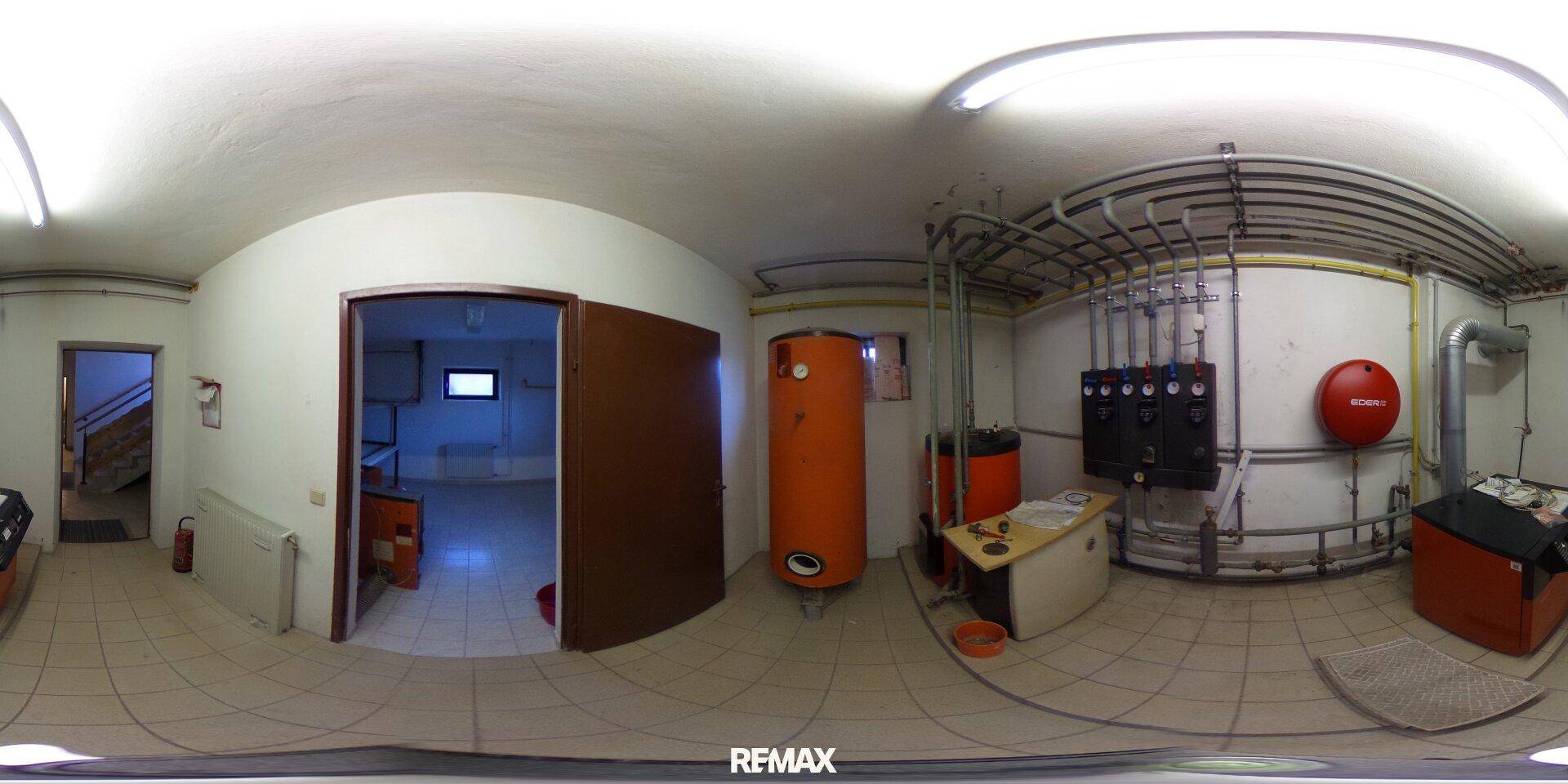 Heizungsraum im Keller mit Warmwasserspeicher und technischen Installationen, funktional und geräumig.