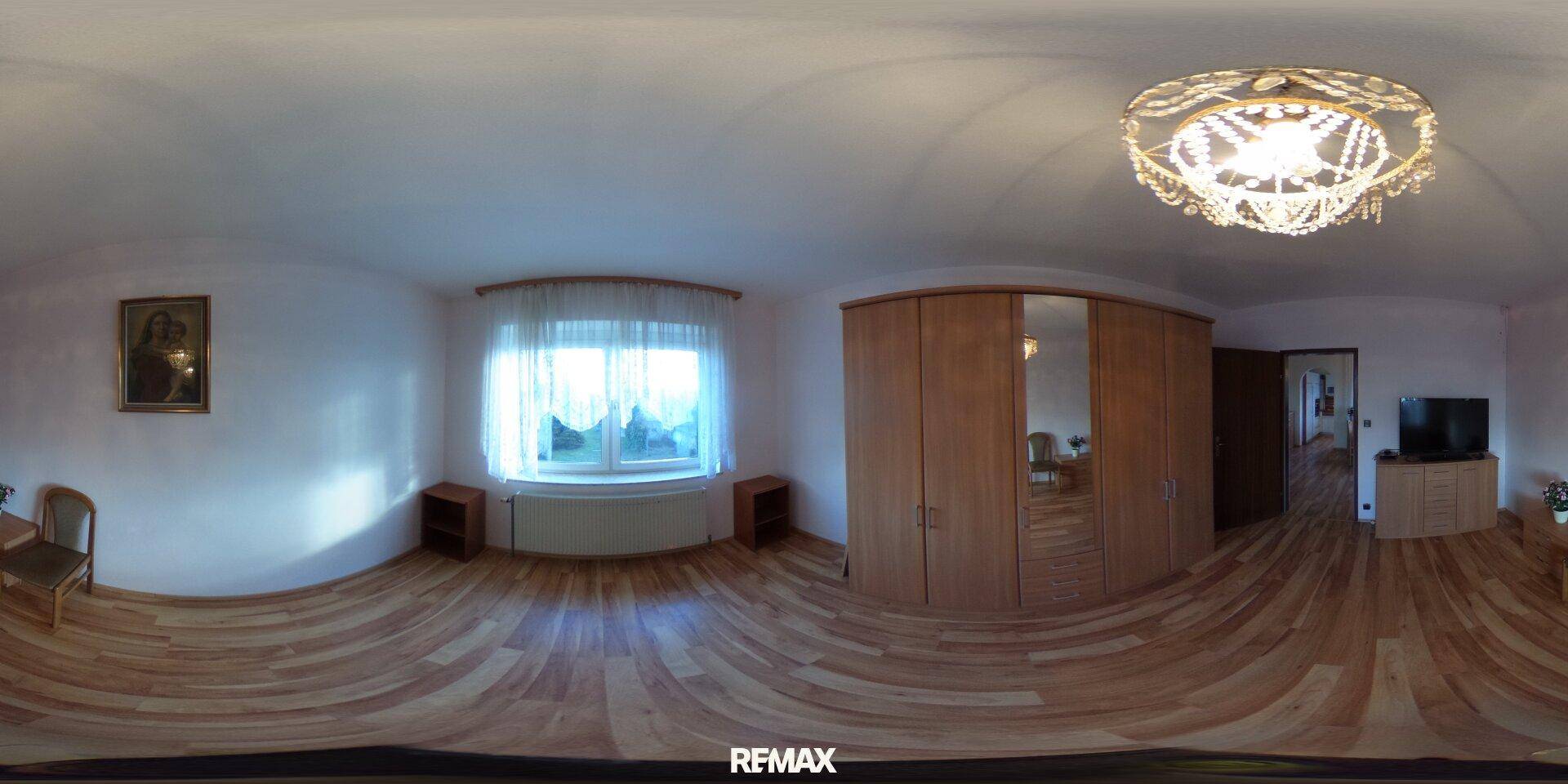 Geräumiges Schlafzimmer mit Holzboden und großem Kleiderschrank, hell und gemütlich.