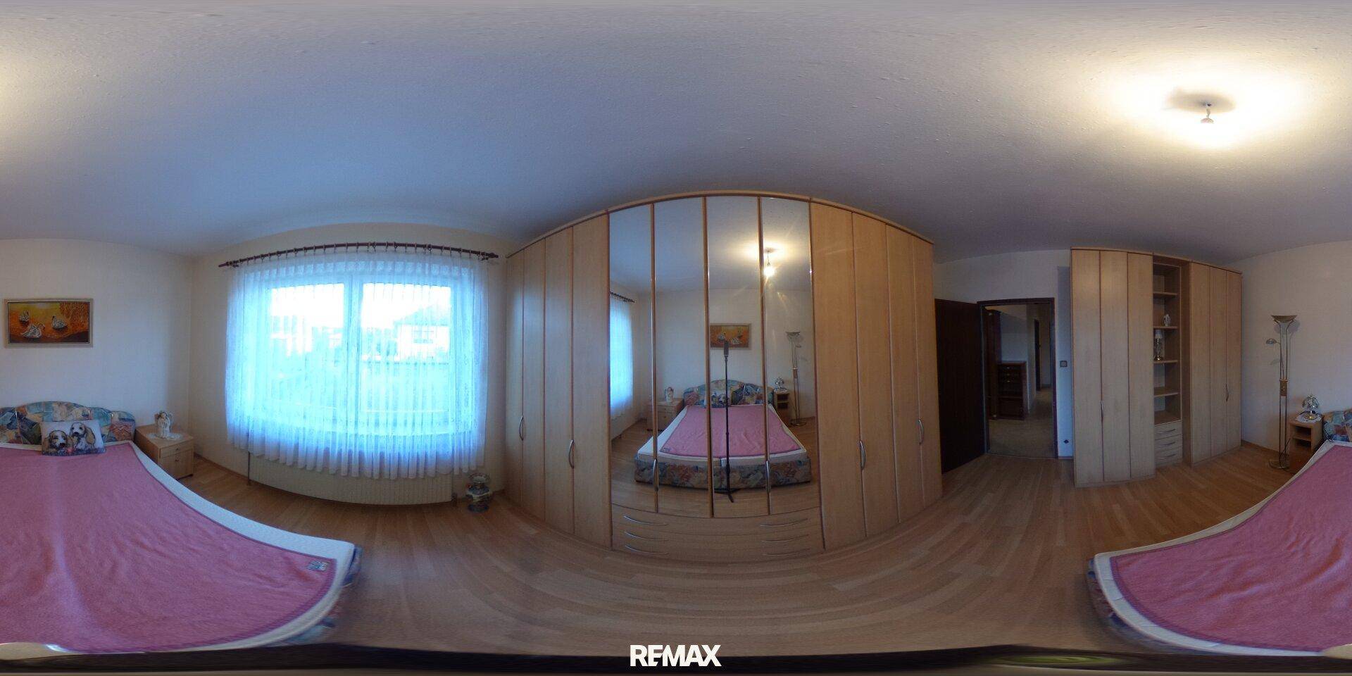 Helles Schlafzimmer mit Holzboden und großem Spiegelschrank, bietet viel Stauraum.