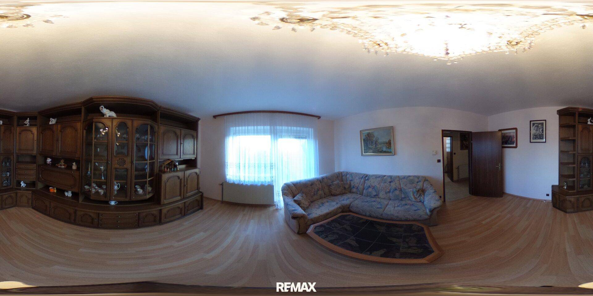 Großes Wohnzimmer mit Holzboden und Ecksofa, bietet viel Platz für Entspannung und Geselligkeit.