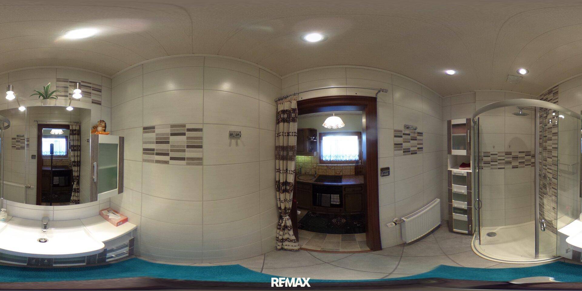 Modernes Badezimmer mit weißen und grauen Fliesen, Einzelwaschbecken und einer geräumigen Duschkabine.