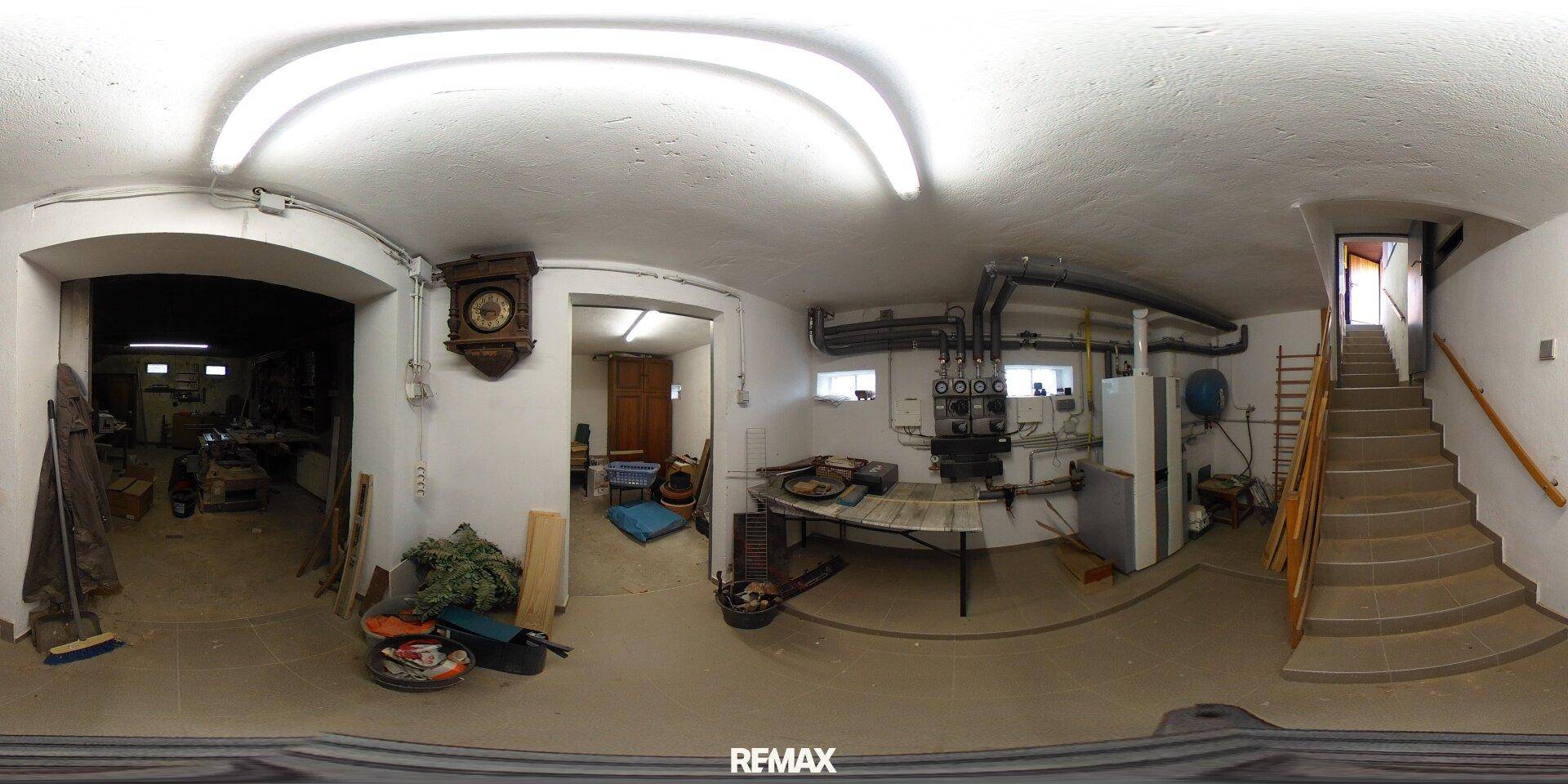 Funktionaler Hauswirtschaftsraum im Keller mit technischen Installationen und Treppenaufgang.