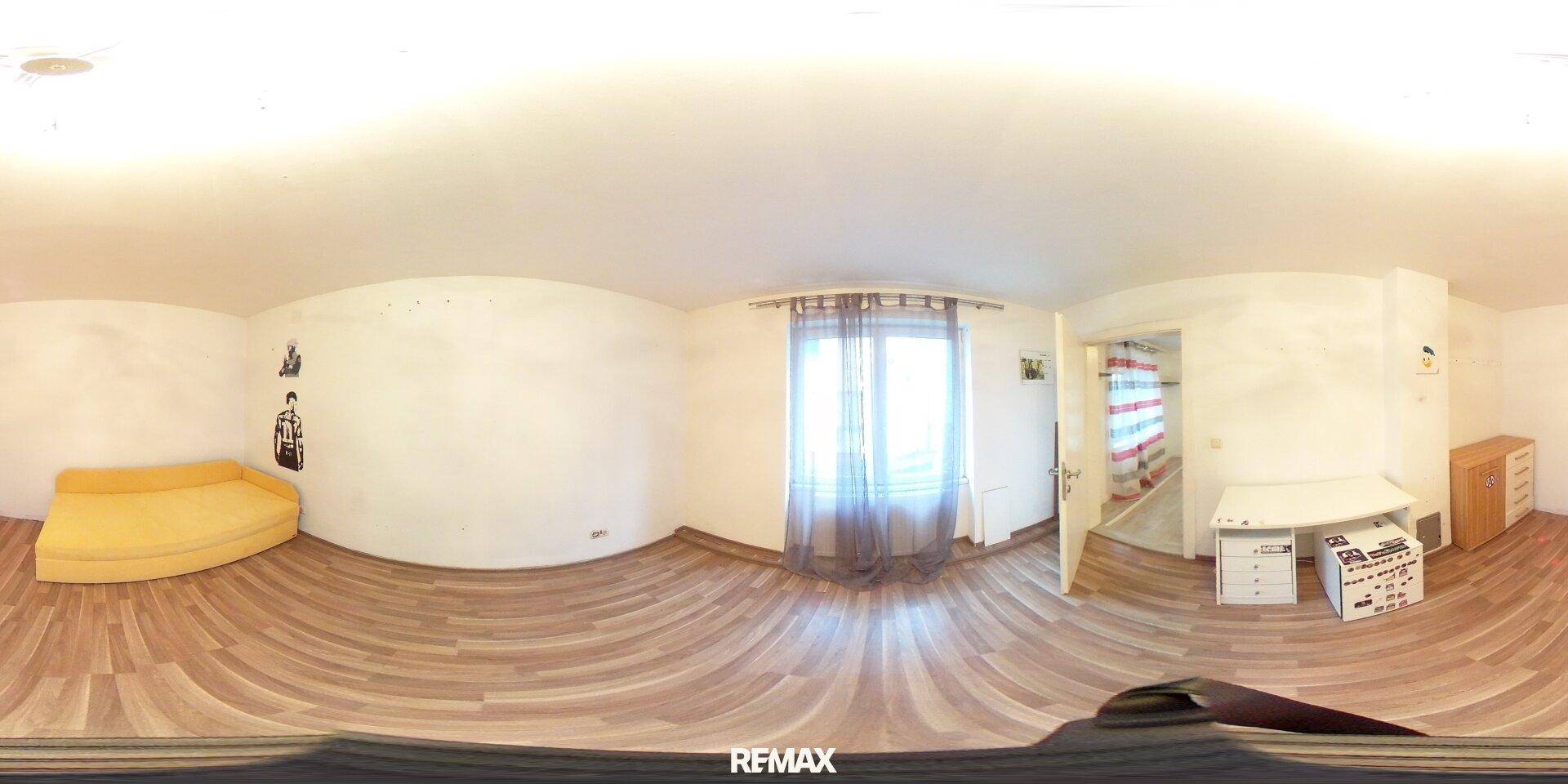 Panoramaaufnahme eines Schlafzimmers mit dunklem Laminatboden und gelbem Schlafsofa.