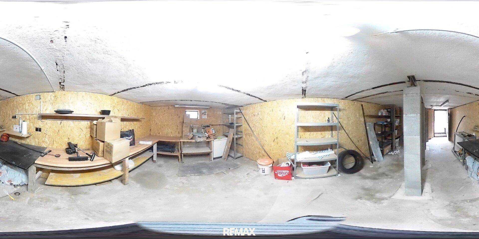 Geräumiger Kellerraum, eingerichtet als Werkstatt mit Holzverkleidung und stabilen Regalsystemen.