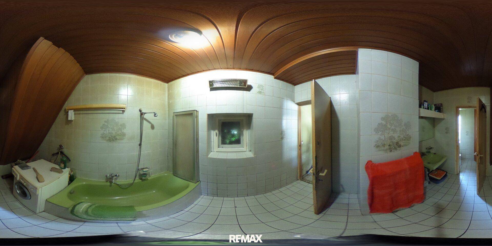 Badezimmer mit grüner Badewanne, Fliesen und Holzdecke, das eine Modernisierung erfordert.