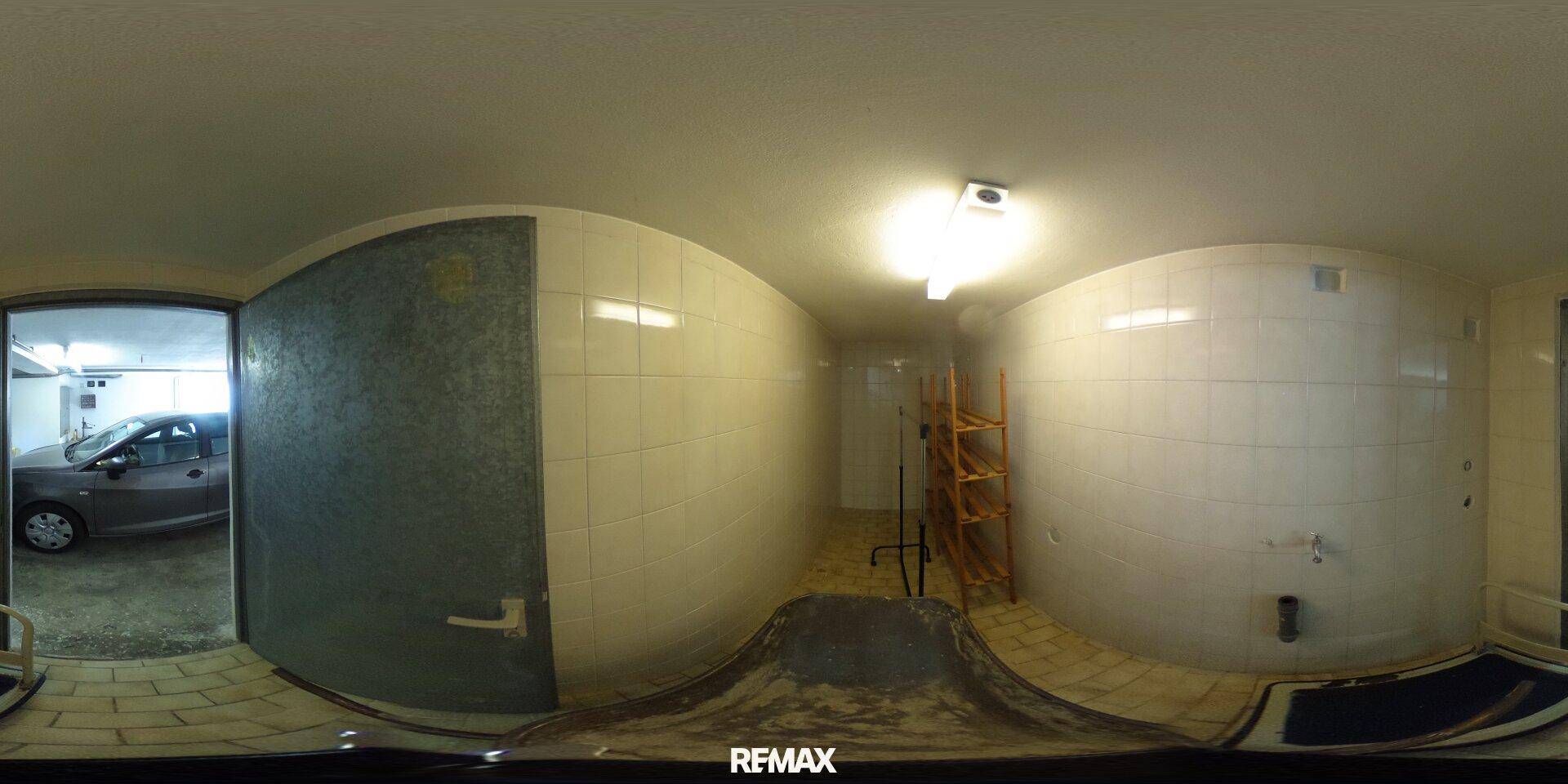 Gefliester Raum, möglicherweise ein Hauswirtschaftsraum, mit Blick in die Garage.