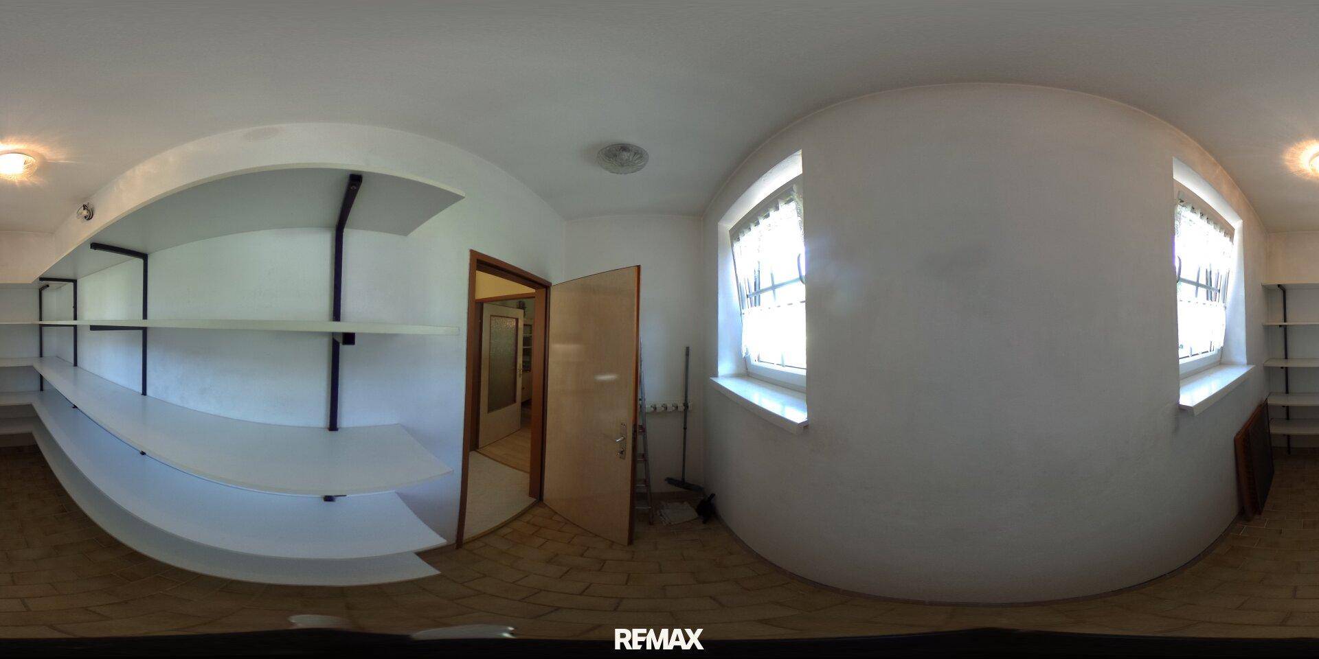 Heller Abstellraum mit weißen Regalen, Fenster und gefliestem Boden für zusätzlichen Stauraum.
