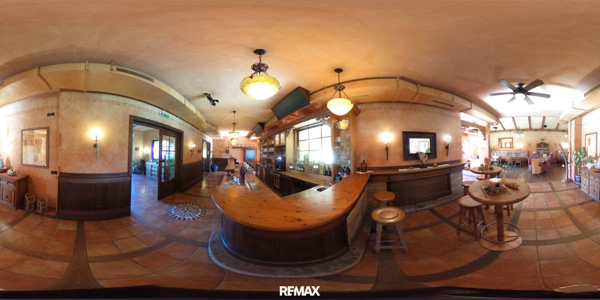 Rustikale Bar mit Holztheke, gemütlicher Beleuchtung und traditionellem Interieur in einem weitläufigen Raum.