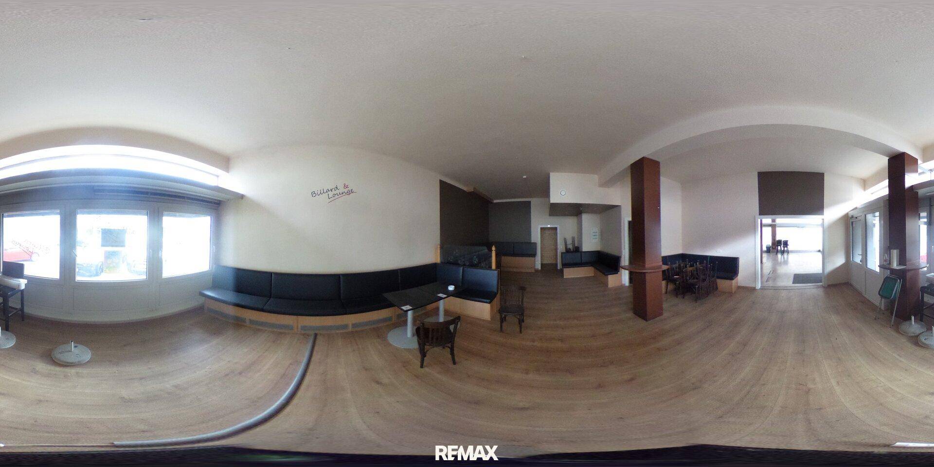 Panoramaansicht eines Gewerberaums mit Holzboden, Sitzbänken und Tischen, bereit für die Neugestaltung.