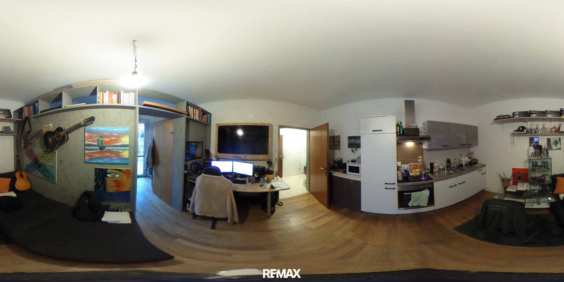 Kombinierter Wohnbereich mit Küche, Arbeitsplatz und Schlafsofa, ideal für kompaktes Wohnen.