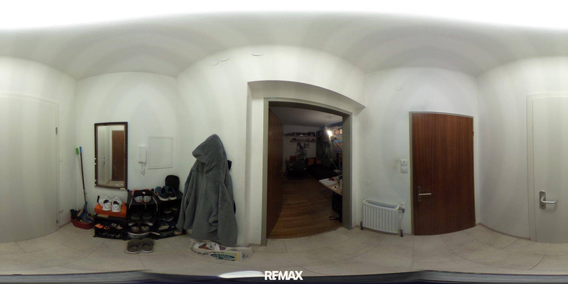 Heller Eingangsbereich mit Garderobe und Schuhregal, führt zu weiteren Räumen.
