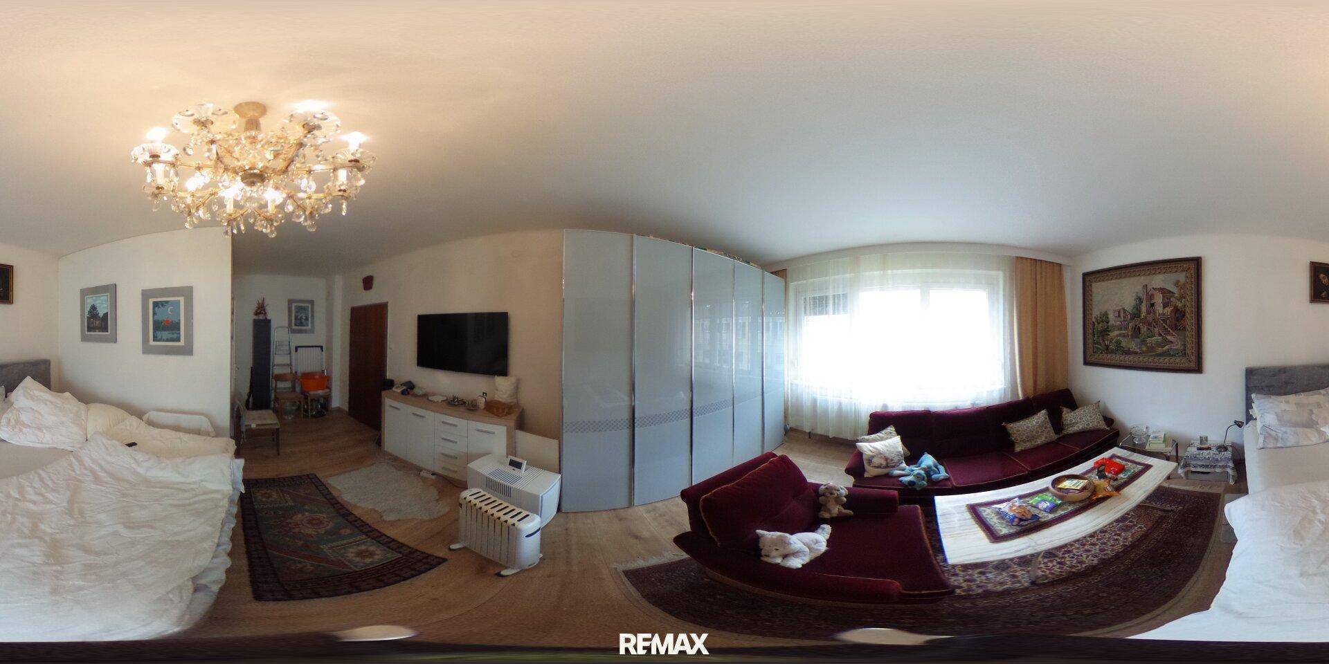 Großer Wohn- und Schlafbereich mit Sofa, Bett und Schrankwand, hell und geräumig.